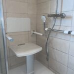 Installation-d-un-siege de-douche-avec accoudoirs-et-barre-de-maintien